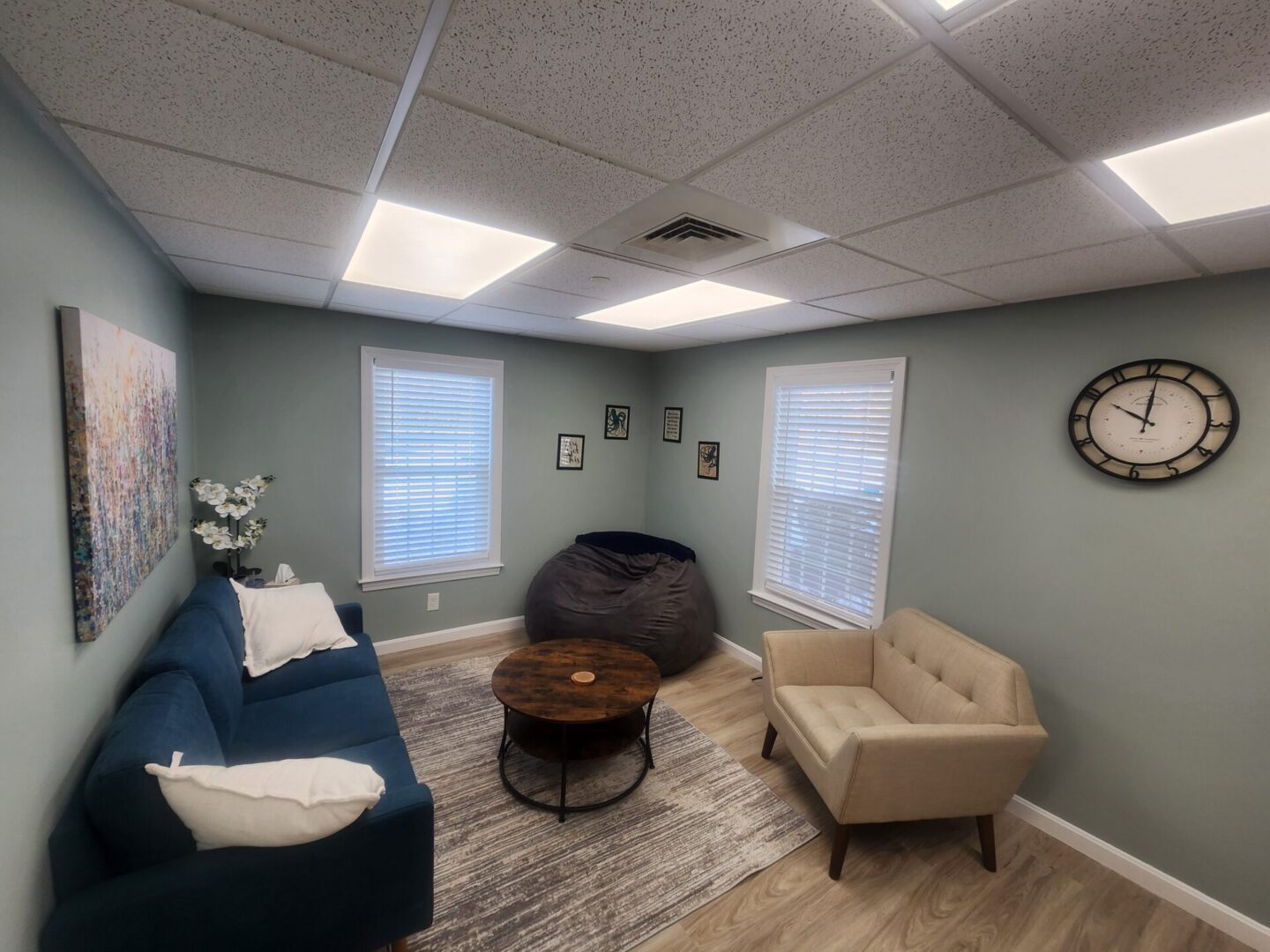 Photo of Sanative Counseling and Wellness Center Suite 103 Office 1.2, featuring a couch, chair, two windows, and a beanbag chair