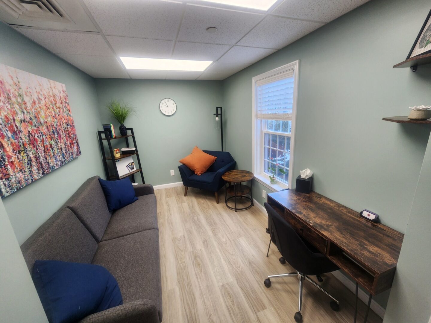 Photo of Sanative Counseling and Wellness Center Suite 103 Office 4 featuring a window, bookshelf, couch, chair, side table, and desk