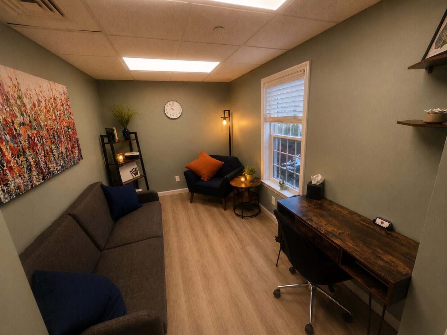 Photo of Sanative Counseling and Wellness Center Suite 103 Office 4 featuring a window, bookshelf, couch, chair, side table, and desk