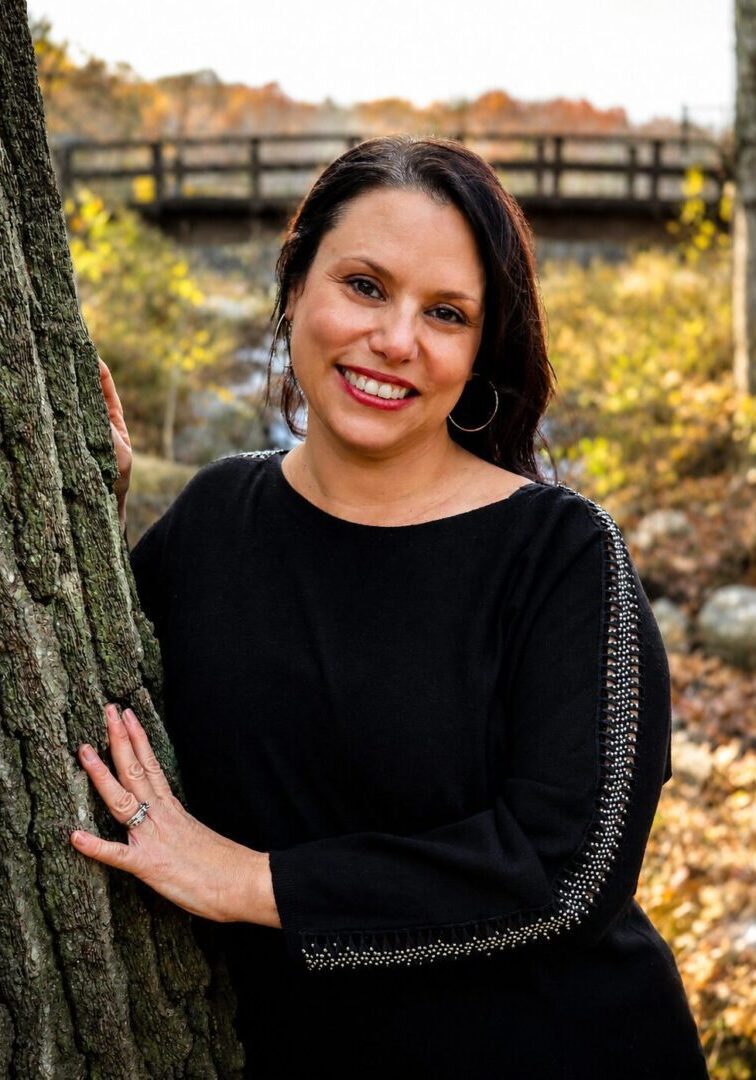 Photo of Nicole Clark, MA, standing against tree outside